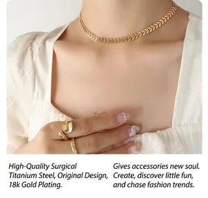 Detail of 18K gold plated titanium necklace with leaf pattern and elegant gold rings