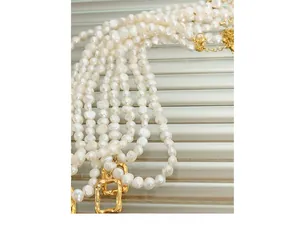 Macro detail of irregular baroque freshwater pearls with a gold rectangular pendant