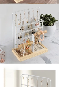 Detail of white iron jewelry stand featuring wooden bars and soft sponge ring slots