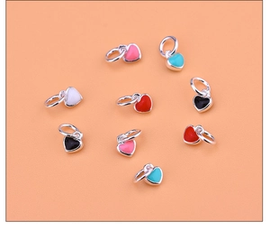 Macro shot of colorful enamel heart pendants with silver metal edges and ring hooks