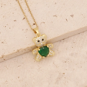 Close-up of golden bear necklace featuring inlaid zircon and a green heart gem