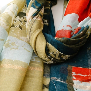 Gros plan d'une écharpe en voile avec lignes dorées et texture douce en coton et lin