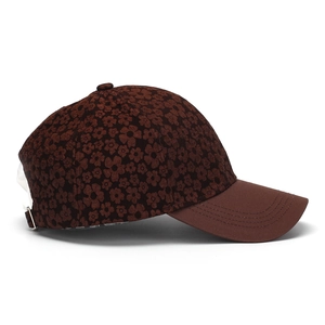 Close-up of brown floral jacquard fabric and metal buckle on the baseball cap