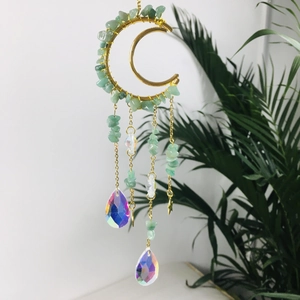 Close-up of golden moon frame with green crystals and prismatic teardrop pendants