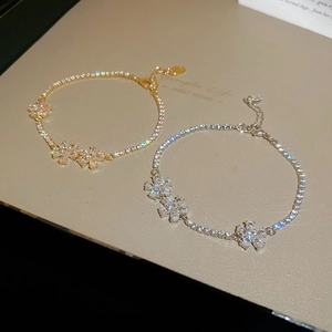 Detailed macro of gold and silver flower bracelets with cubic zirconia on a tennis chain