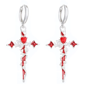 Close-up of gothic silver cross earrings with red heart gem and thorn vine details