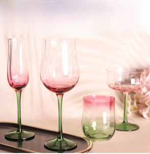 Detail of red and green gradient glass stemware set on a black metal display tray