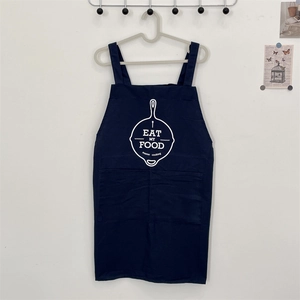 Detail of navy blue cotton apron with white cooking icon and double front pockets