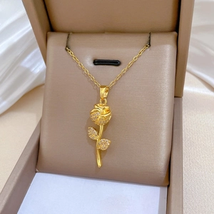 Close-up of rose flower pendant with cubic zirconia inlay on elegant satin background