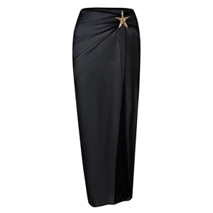 Detail of black high-waisted satin skirt with starfish buckle and side slit