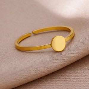 Detail of adjustable gold-tone stainless steel ring with a polished circular disc on silk
