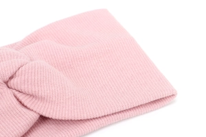 Close-up of pink knitted baby headband showing the soft texture and twist knot detail