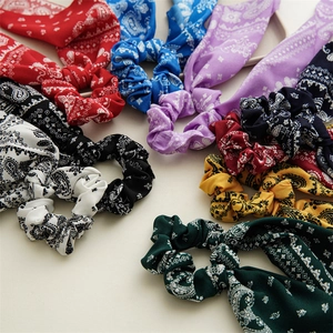 Flat lay of colorful paisley print scrunchies in various shades on a white surface