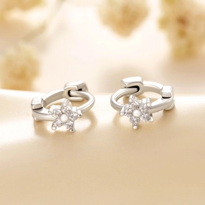 Minimalist silver flower hoop earrings with zircon stones in a floral setting