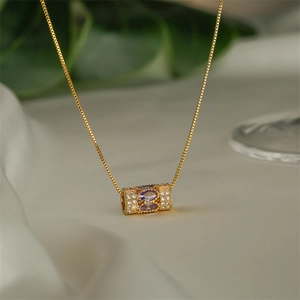 Elegant gold necklace with purple oval gemstones and zircon accents on a cylinder pendant