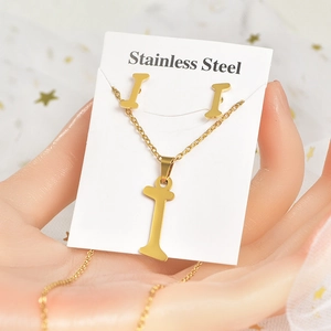 Dettaglio del set collana e orecchini in acciaio inossidabile dorato con lettera I