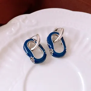 Boucles d'oreilles vintage en argent avec émail bleu fleuri sur une assiette en céramique