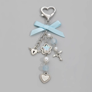 Detail of silver heart lock and star charms on a blue ribbon bow with faux pearls