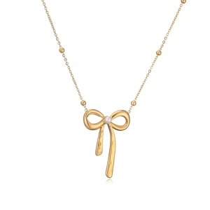 Vue détaillée du pendentif nœud doré avec perle blanche et chaîne à billes délicate