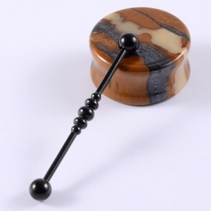 Polished natural stone ear gauges and black metal barbell piercing set on white background