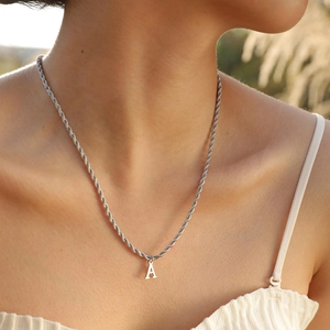 Detailed shot of a silver polished stainless steel rope chain with a capital letter A pendant