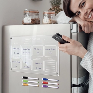 Clear acrylic magnetic weekly planner on fridge with six colorful dry erase markers
