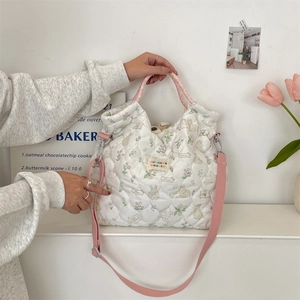 Détail du sac matelassé avec imprimé lapin fleuri et bandoulière rose amovible