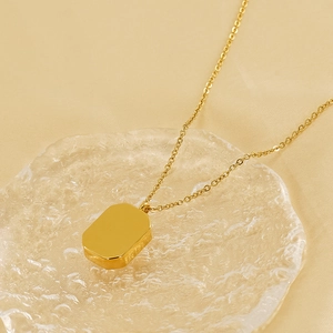 Elegant gold stainless steel necklace with rectangular zircon pendant on glass base