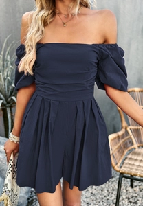 Detail of navy blue off-shoulder romper with puff sleeves and pleated waist design
