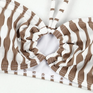 Détail macro du haut de bikini à rayures brunes avec texture gaufrée et anneau central