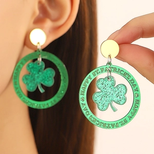 Gros plan de boucles d'oreilles St. Patrick en acrylique vert avec trèfle et texte