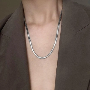 Polished silver snake chain necklace shown on a model in a professional business setting