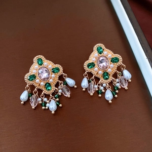 Detailed macro of vintage emerald and pink crystal earrings with pearl tassel drop