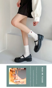 Close-up of white cotton socks with cherry embroidery paired with black pearl Mary Janes