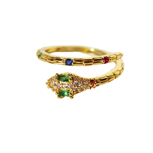 Snake open ring in gold with colorful zircons and green gemstones on white background