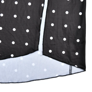 Detailed close-up of black and white polka dot fabric texture and hem stitching quality