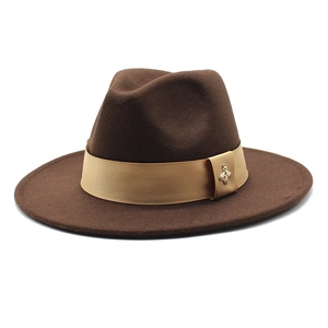 Detail of dark brown wool fedora with khaki satin ribbon and golden bee ornament