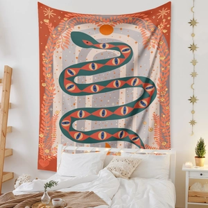Bohemian wall tapestry with mystic snake and sun design in a cozy bedroom setting