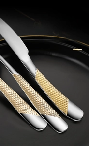 Macro detail of luxury stainless steel cutlery handle with golden diamond star pattern