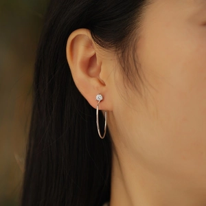 Elegant S925 sterling silver hoop earrings with round moissanite stone worn by a model