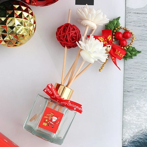 Christmas reed diffuser set with glass bottle, red ribbon, and festive floral ornaments
