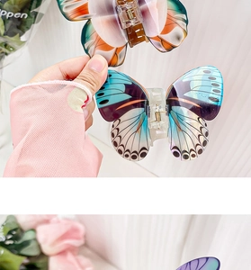 Macro detail of translucent butterfly hair claw clips with colorful printed wing patterns