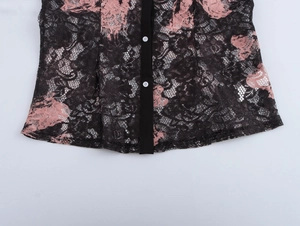 Detail of black lace shirt hem featuring pink floral patterns and white buttons
