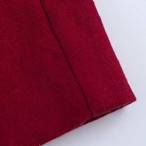 Detail of burgundy linen fabric showing woven texture and high-quality stitching edges