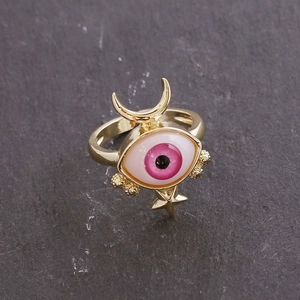 Macro detail of 18K gold ring featuring a pink eye motif with moon and star accents
