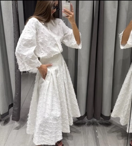 Détail d'un ensemble deux pièces blanc avec texture complexe à franges et glands 3D