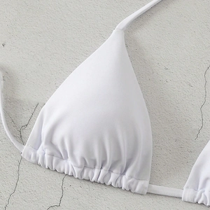 Close-up of white halter bikini top with ruched triangle cups and neck ties detail