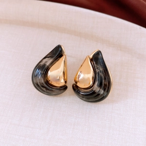 Macro detail of tear-drop earrings with tortoiseshell resin and 18K gold plated metal