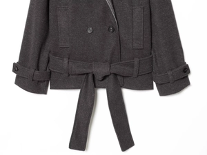 Detail view of double-breasted grey wool coat featuring waist belt and cuff strap details