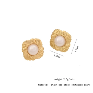 Macro shot of gold stainless steel heart stud earrings with imitation pearl detailing